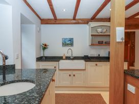 A kitchen with a sink and cabinets at Pylemoor Cottage in Washfield near Tiverton