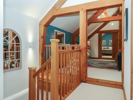 A hallway with a staircase and framed pictures at Pylemoor Cottage Washfield near Tiverton