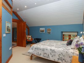 A bedroom with a bed and paintings on the wall at Pylemoor Cottage in Washfield near Tiverton