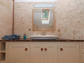 A bathroom with a sink and mirror at Pylemoor Cottage in Washfield near Tiverton