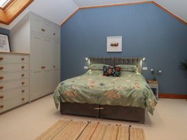 A bedroom with a bed and wardrobe at Pylemoor Cottage in Washfield near Tiverton