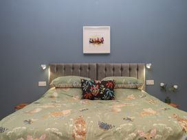 A bedroom with a bed and wall art at Pylemoor Cottage in Washfield near Tiverton