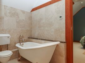 A bathroom with a bathtub and toilet at Pylemoor Cottage in Washfield near Tiverton