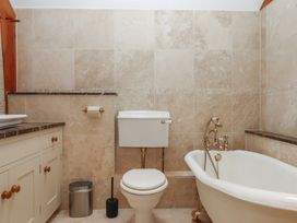 A bathroom with a bathtub, toilet, and sink at Pylemoor Cottage in Washfield near Tiverton