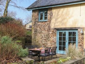 An outdoor seating area with a table and chairs at Pylemoor Cottage in Washfield near Tiverton