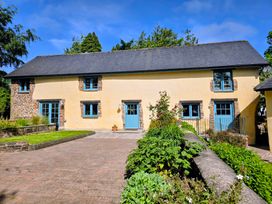 A house with windows and a door in an outdoor area at Pylemoor Cottage in Washfield near Tiverton