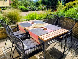 An outdoor dining area with a table and chairs at Pylemoor Cottage in Washfield near Tiverton