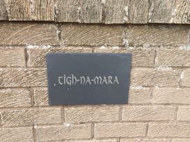 A slate sign with the name Tigh-Na-Mara on a wall