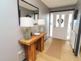 A hallway with a console table, lamps, and a mirror at Tigh-Na-Mara Retreat