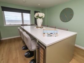 A kitchen with a table and chairs overlooking the sea at Tigh-Na-Mara Retreat