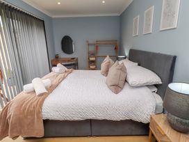 A bedroom with a bed and a shelf at Tigh-Na-Mara Retreat