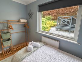 A bedroom with a bed and storage shelves at Tigh-Na-Mara Retreat