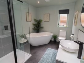 A bathroom with a bathtub, toilet, sink, and shower at Tigh-Na-Mara Retreat