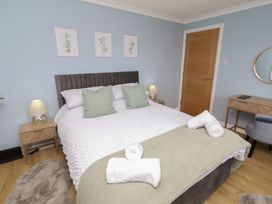 A bedroom with a bed and bedside table at Tigh-Na-Mara Retreat