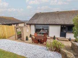 A patio area with a table and chairs at Tigh-Na-Mara Retreat in 