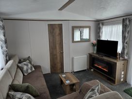 A living room with a sofa and television at River Meadow 61 Northampton