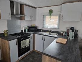 A kitchen with a stove, sink, and microwave at River Meadow 61 Northampton