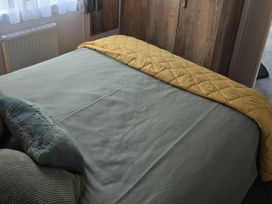 A bed with a yellow blanket and pillows at River Meadow 61 Northampton