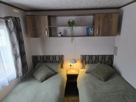 A bedroom with two single beds and storage at River Meadow 61 Northampton