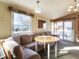 A living room with a sofa and coffee table at Ocean Breeze Escape in Allhallows