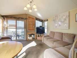 A living room with a sofa and television at Ocean Breeze Escape Allhallows
