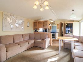 A living room with a sofa and table at Ocean Breeze Escape in Allhallows