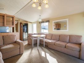 A living room with seating and a table at Ocean Breeze Escape in Allhallows
