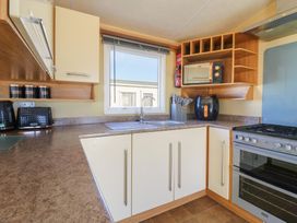 A kitchen with a sink, gas stove, and microwave at Ocean Breeze Escape in Allhallows