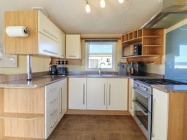 A kitchen with cabinets and appliances at Ocean Breeze Escape in Allhallows