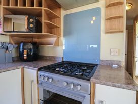 A kitchen with a gas stove and microwave at Ocean Breeze Escape in Allhallows