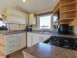 A kitchen with sink and gas stove at Ocean Breeze Escape, Allhallows
