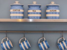 A kitchen with striped containers and mugs at The Old Studio in Penzance