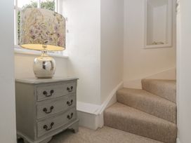 A staircase with a lamp and table at The Old Studio in Penzance