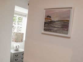 A room with a painting on the wall and a lamp on a chest of drawers at The Old Studio in Penzance