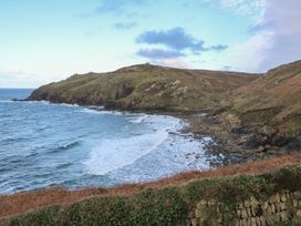 A coastline with waves and a hill at The Old Studio in Penzance