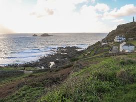 A coastal view with rocks and houses at The Old Studio in Penzance