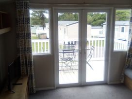 A living room with a sliding door leading to a deck at Caravan in Newquay