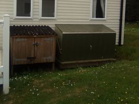 A wooden shed and storage box outside a building at Caravan in Newquay