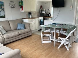 A living room with a sofa and a dining table at Chalet - Buckland 16 in Bideford