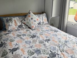 A bedroom with a bed and decorative pillows at Chalet - Buckland 16, Bideford