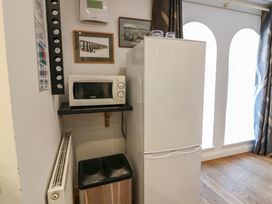 A kitchen area with a microwave and refrigerator at Mill Wharf in Berwick-upon-Tweed