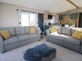 A living room with sofas and a kitchen area at 0028 South Beach