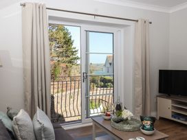 A living room with a view through a window at 3 The Elms in Salcombe