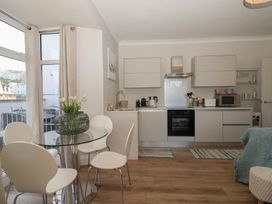 A kitchen with a glass table and chairs at 3 The Elms Salcombe