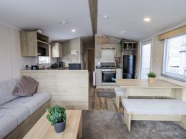 A living room with a sofa and dining area at Hadrian's Rest in Wigton