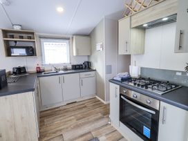 A kitchen with cabinets and appliances at Hadrian's Rest in Wigton