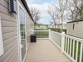 An outdoor decking area with a railing and storage box at Hadrian's Rest in Wigton