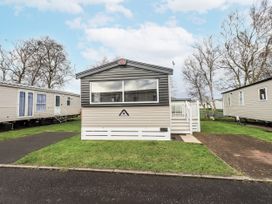 A mobile home with steps and grass outside at Hadrian's Rest in Wigton