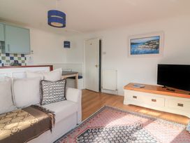 A living room with a sofa and television at 4 The Elms in Salcombe