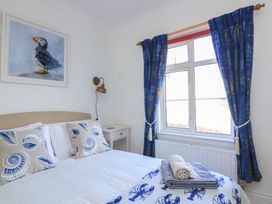 A bedroom with a bed and blue curtains at 4 The Elms in Salcombe